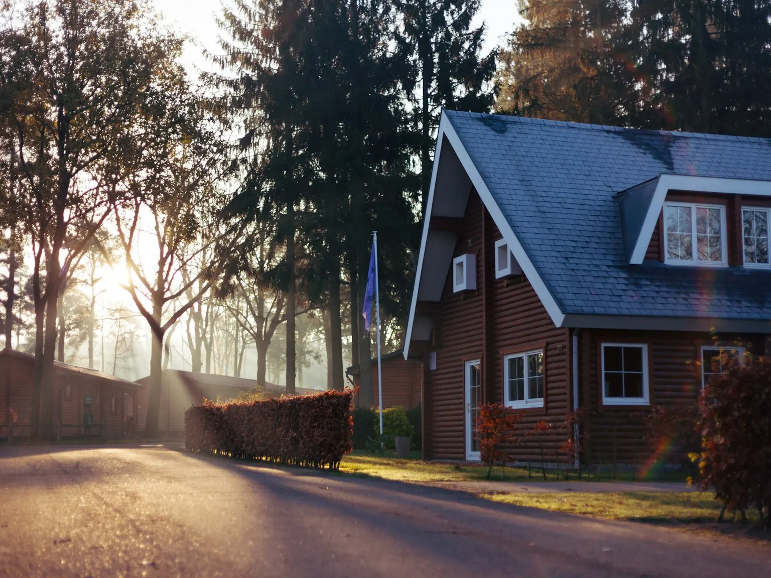 Timber farmhouse at the end of a country lane in golden light