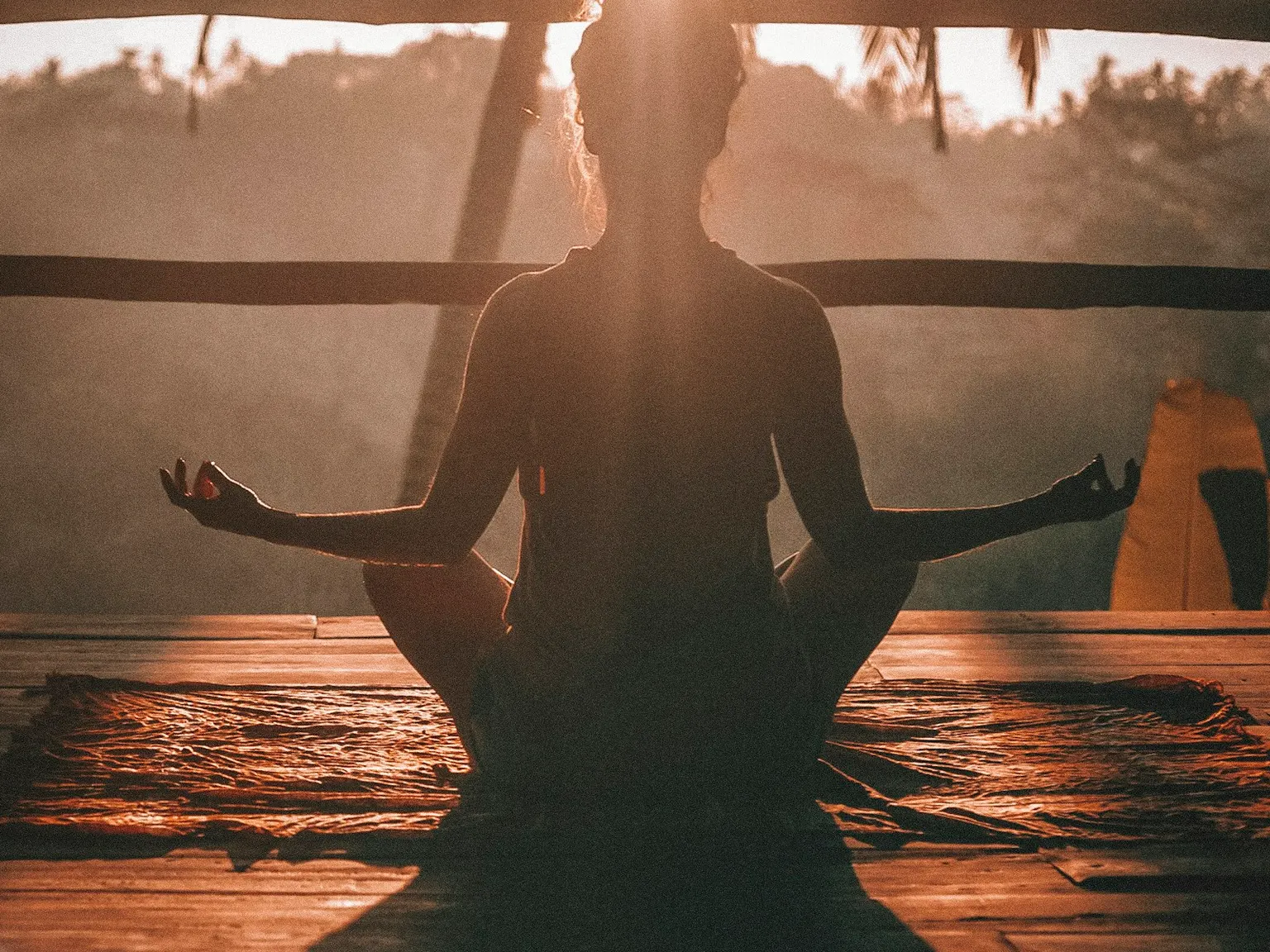 Person meditating outdoors in a peaceful green field
